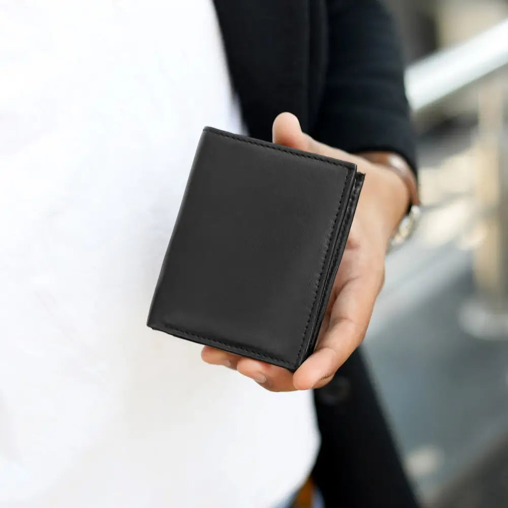 Person holding Basic Wallet Style 48, showing compact trifold wallet in hand.