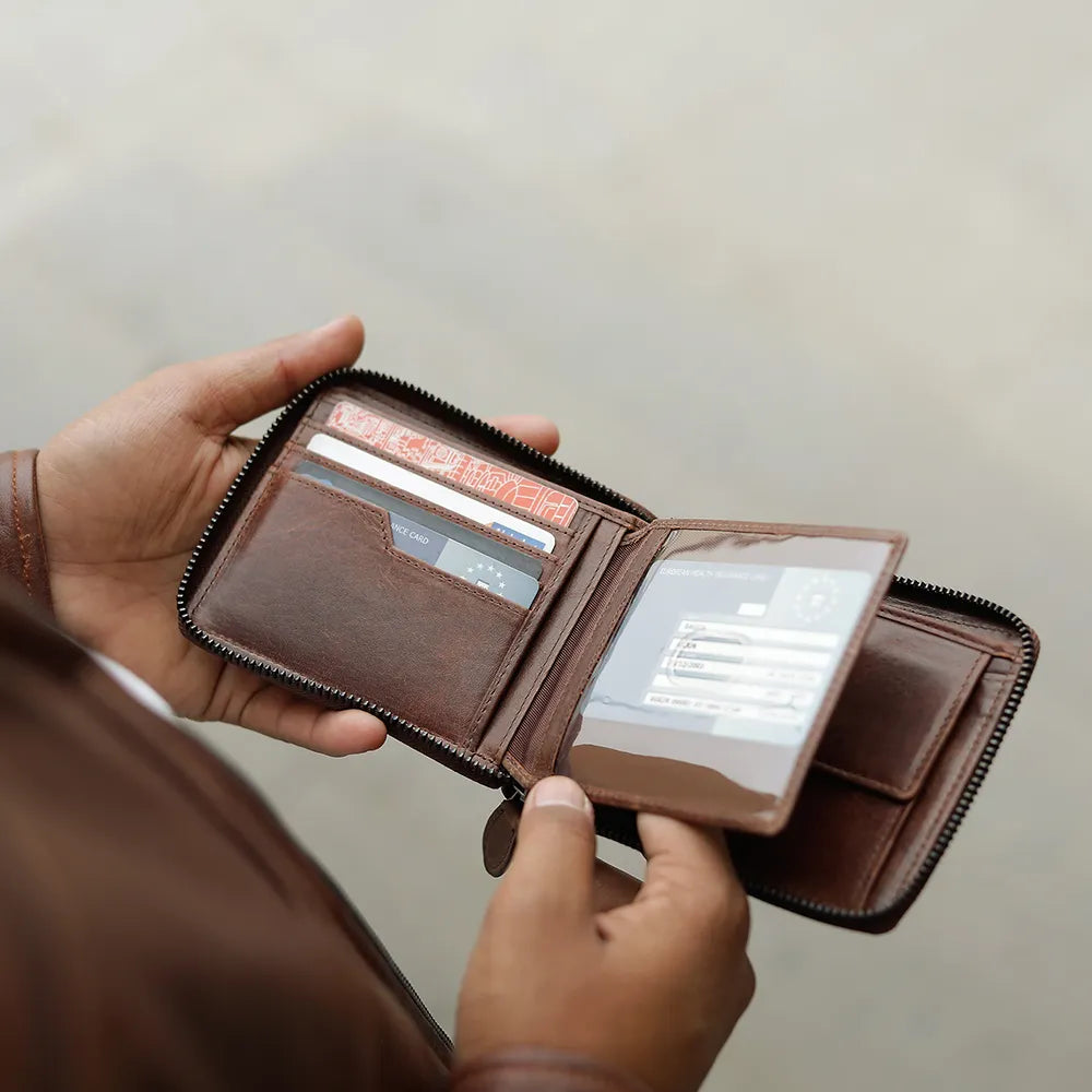 Man holding brown leather zip-around wallet - Alperto 4257, showcasing durable zip closure and compact design.