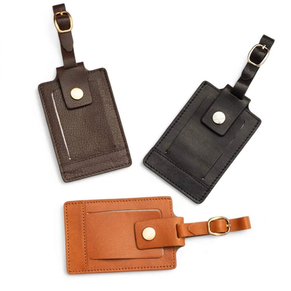 Flatlay of three leather luggage tags in brown, black, and tan arranged diagonally – SKU 901.
