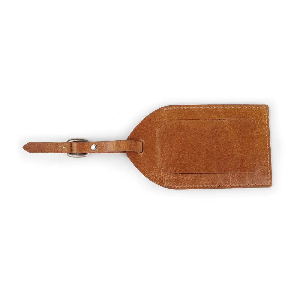 Top view of tan full-grain leather luggage tag showing ID window, flap cover, and buckle strap.