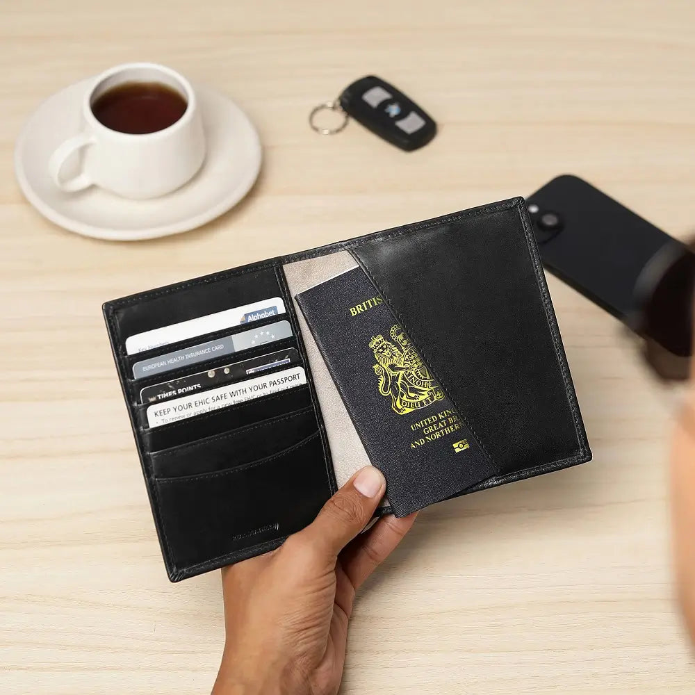 Black leather passport wallet on desk beside coffee cup,car key and mobile