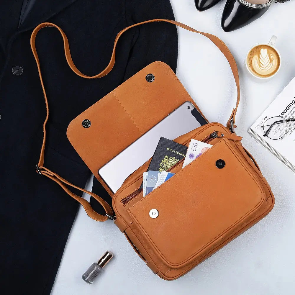 Tan leather crossbody bag flat lay showing full exterior, adjustable strap, and compact structured design.