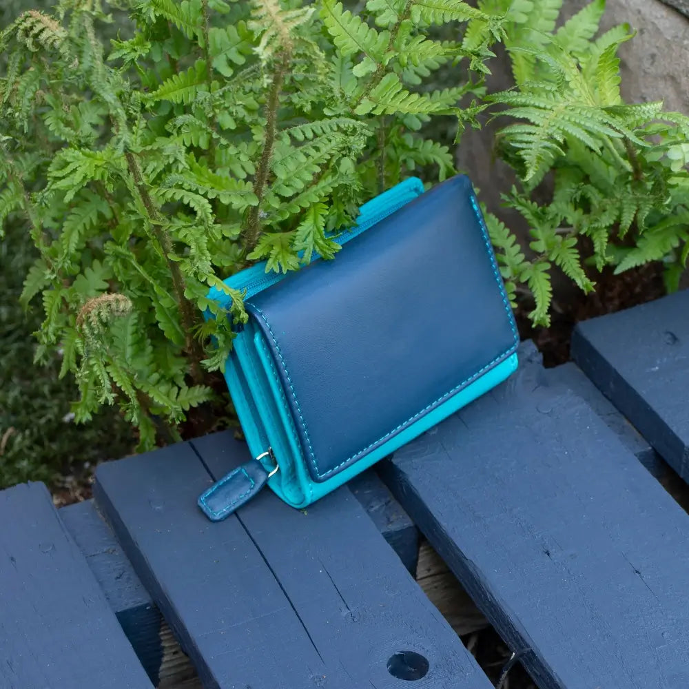 Front view of navy RFID Secure trifold leather purse with tab fastener and zipped coin pocket