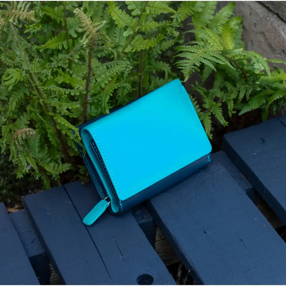 Front view of turquoise RFID Secure trifold leather purse with tab fastener and zipped coin pocket