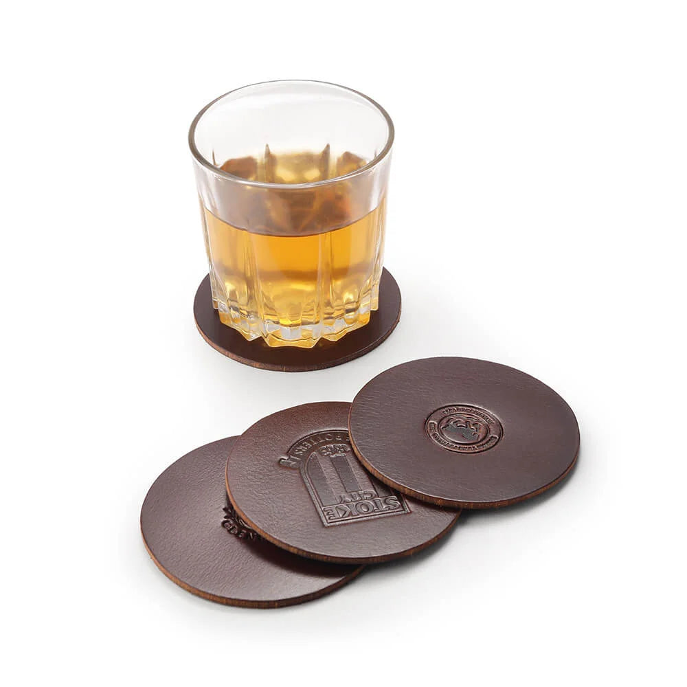 Branded leather coaster gift sets with custom embossed logos in gold tin