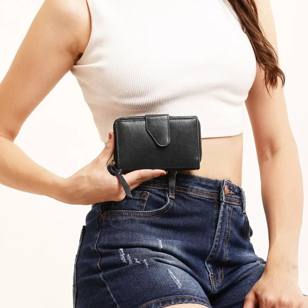Person wearing a black purse with a neutral background