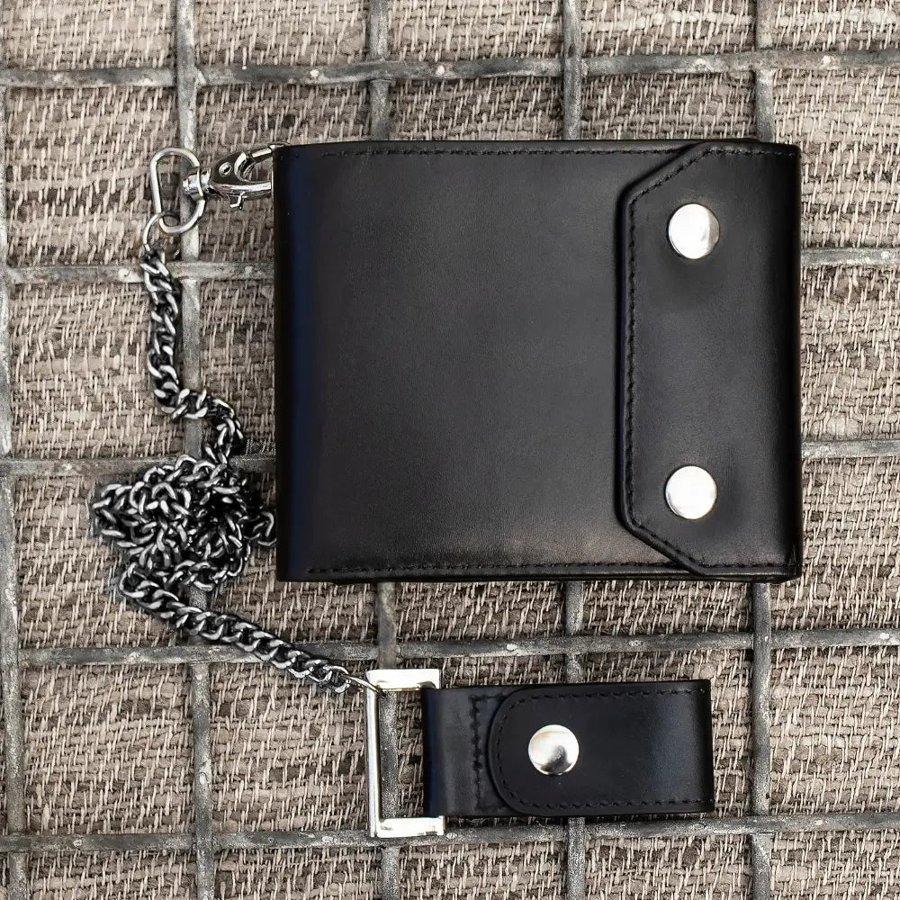 Black leather wallet with chain on a textured surface