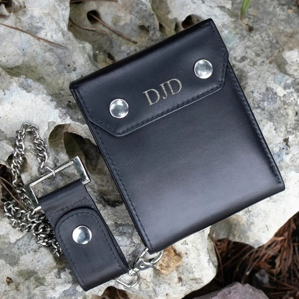 Black leather wallet with chain on a textured surface