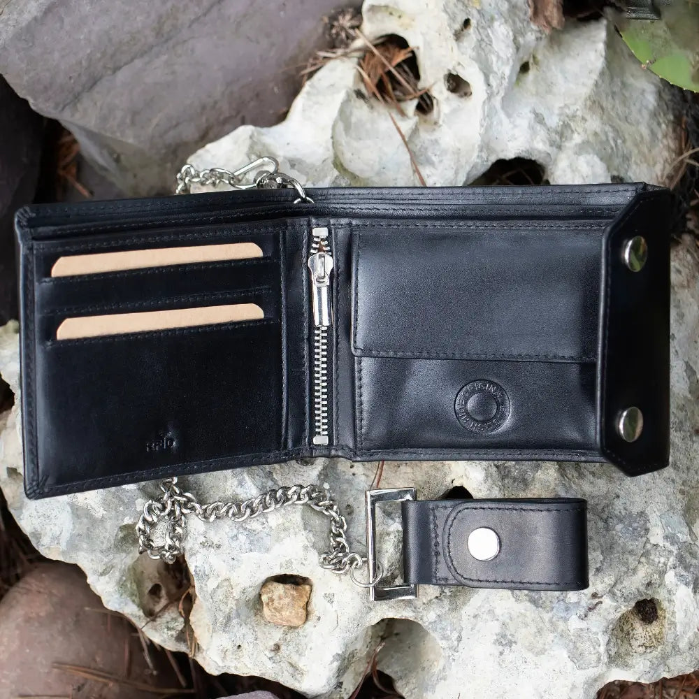 Black leather wallet with chain on a rocky surface