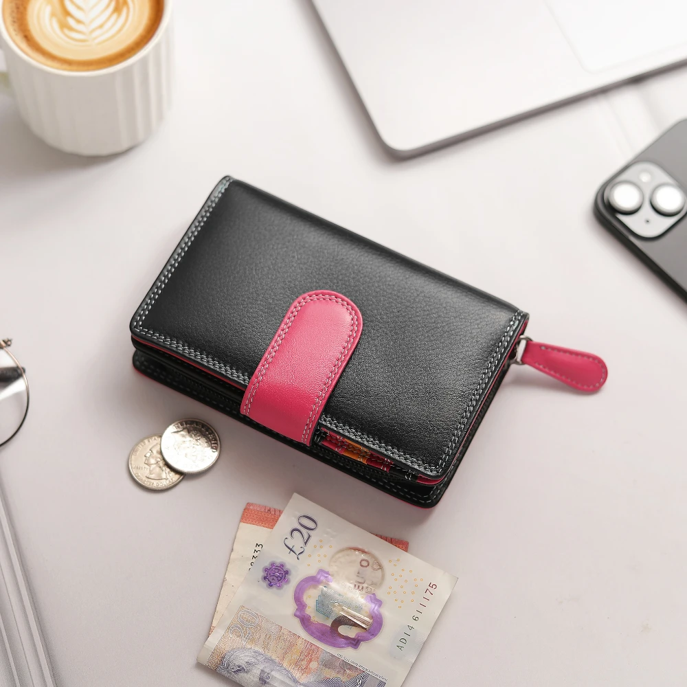 Black and pink wallet with money and a cup of coffee on a white surface