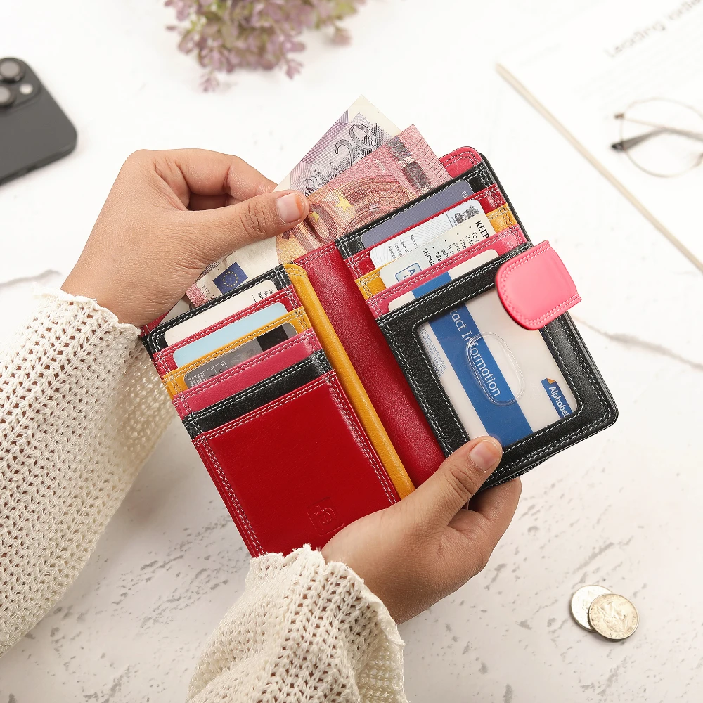 Person holding a black wallet with various cards and money on a light surface.