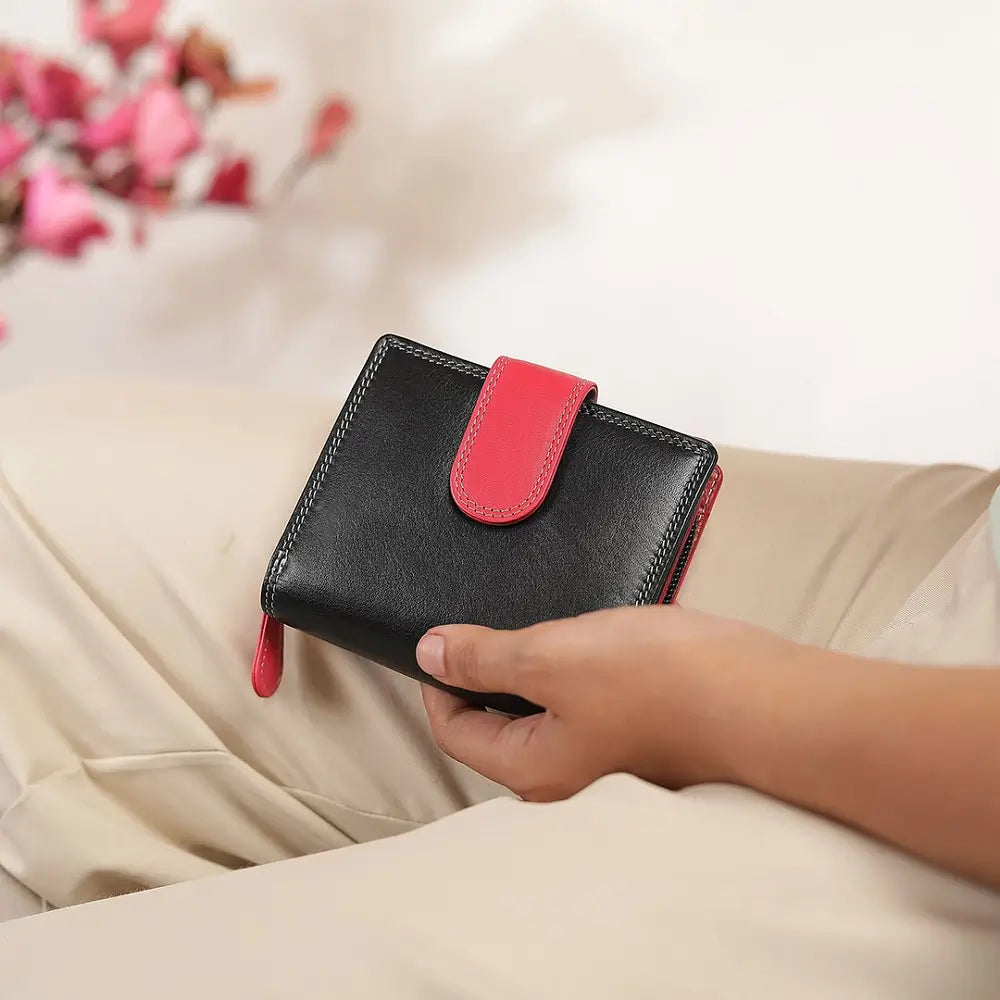 Person holding Black wallet with a red accent on a white background