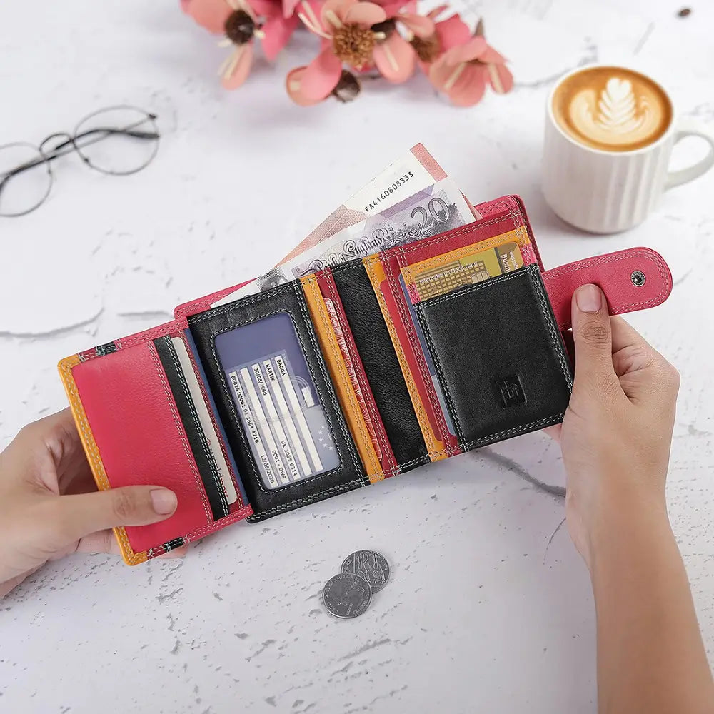 Lifestyle view of Black and red wallet with coins and a banknote on a wooden surface
