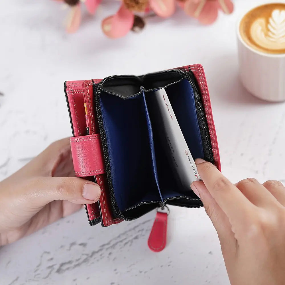 Person opening a black wallet with a coffee cup and flowers in the background