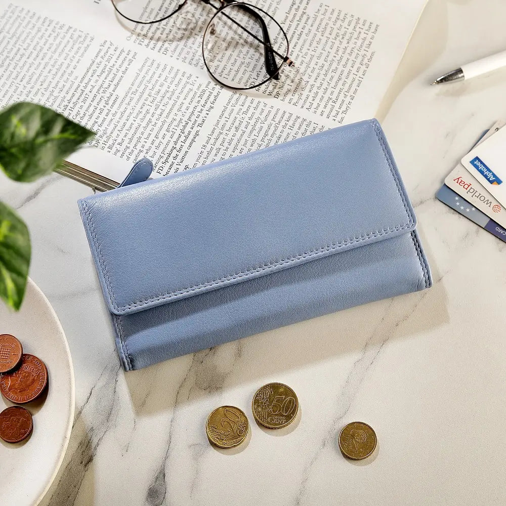 Blue wallet on a marble surface with coins and reading material