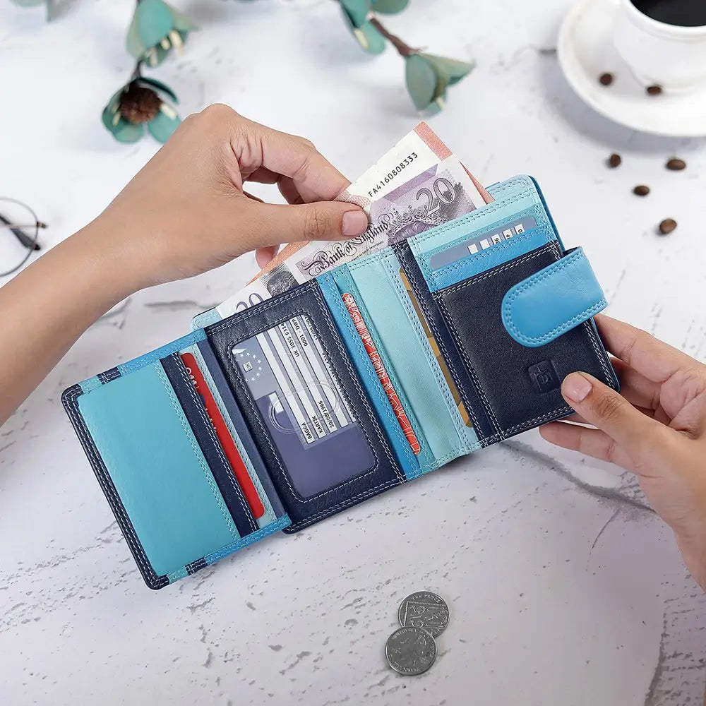 Blue wallet with money and cards on a light surface