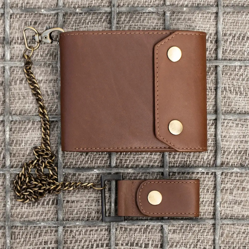 Brown leather wallet with keychain on a textured surface
