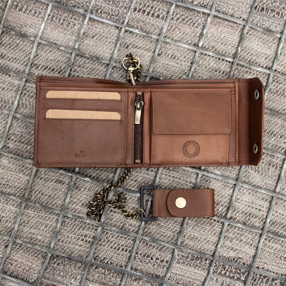 Brown leather wallet with keychain on a textured surface