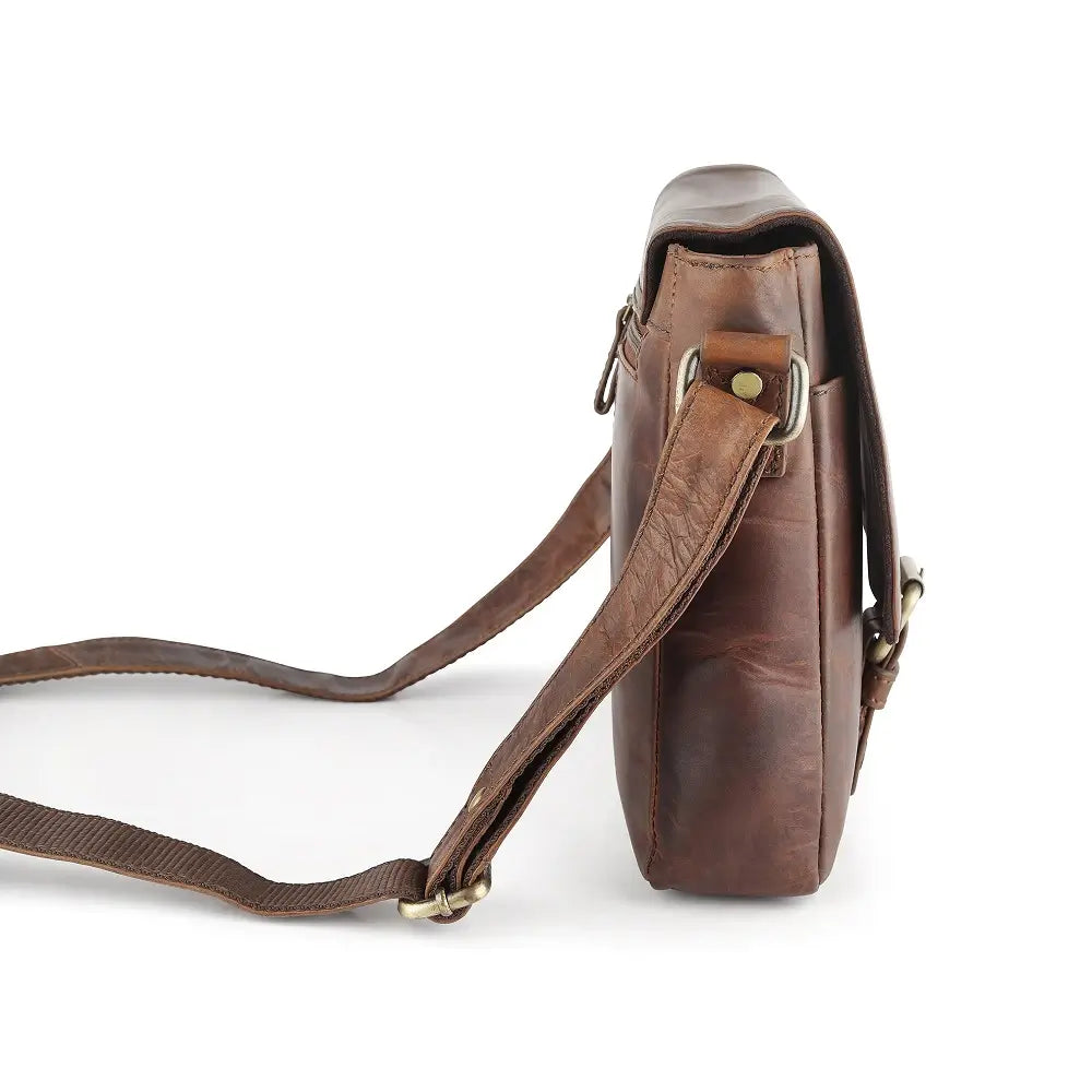 Brown leather crossbody bag with a strap on a white background