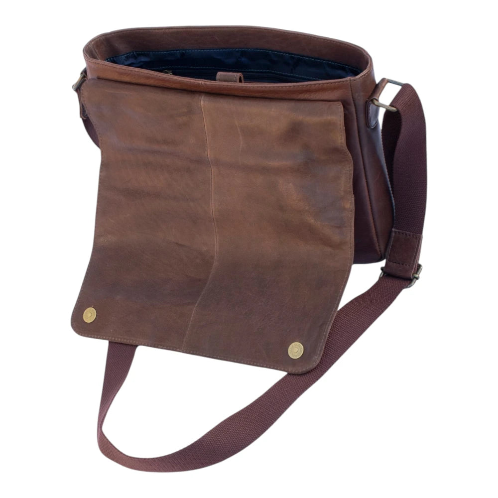 Brown leather bag with a strap on a white background