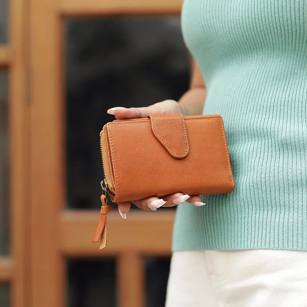 Person holding a cognac wallet with a blurred background