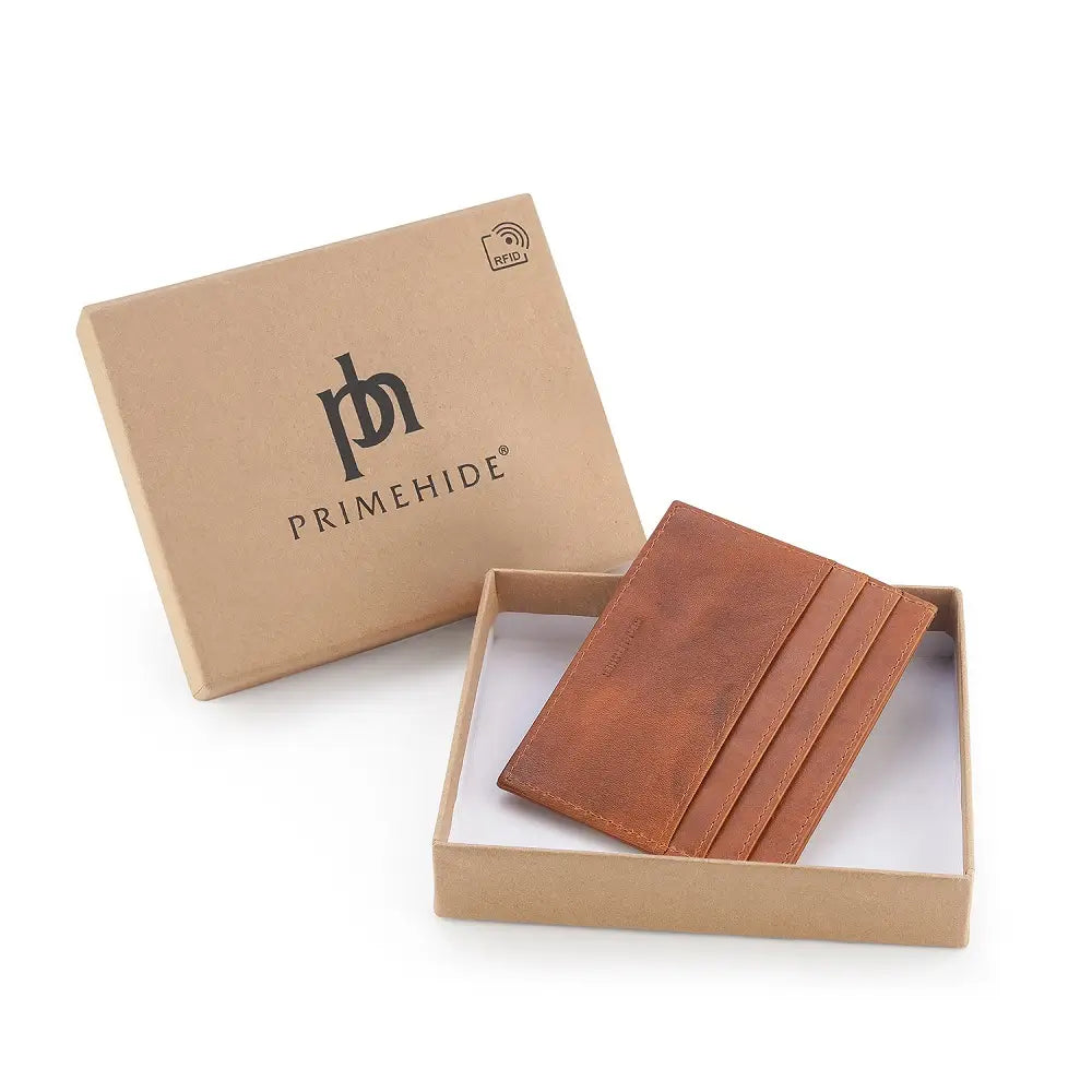 Cognac leather cardholder with four slots in a Primehide branded box on a white background