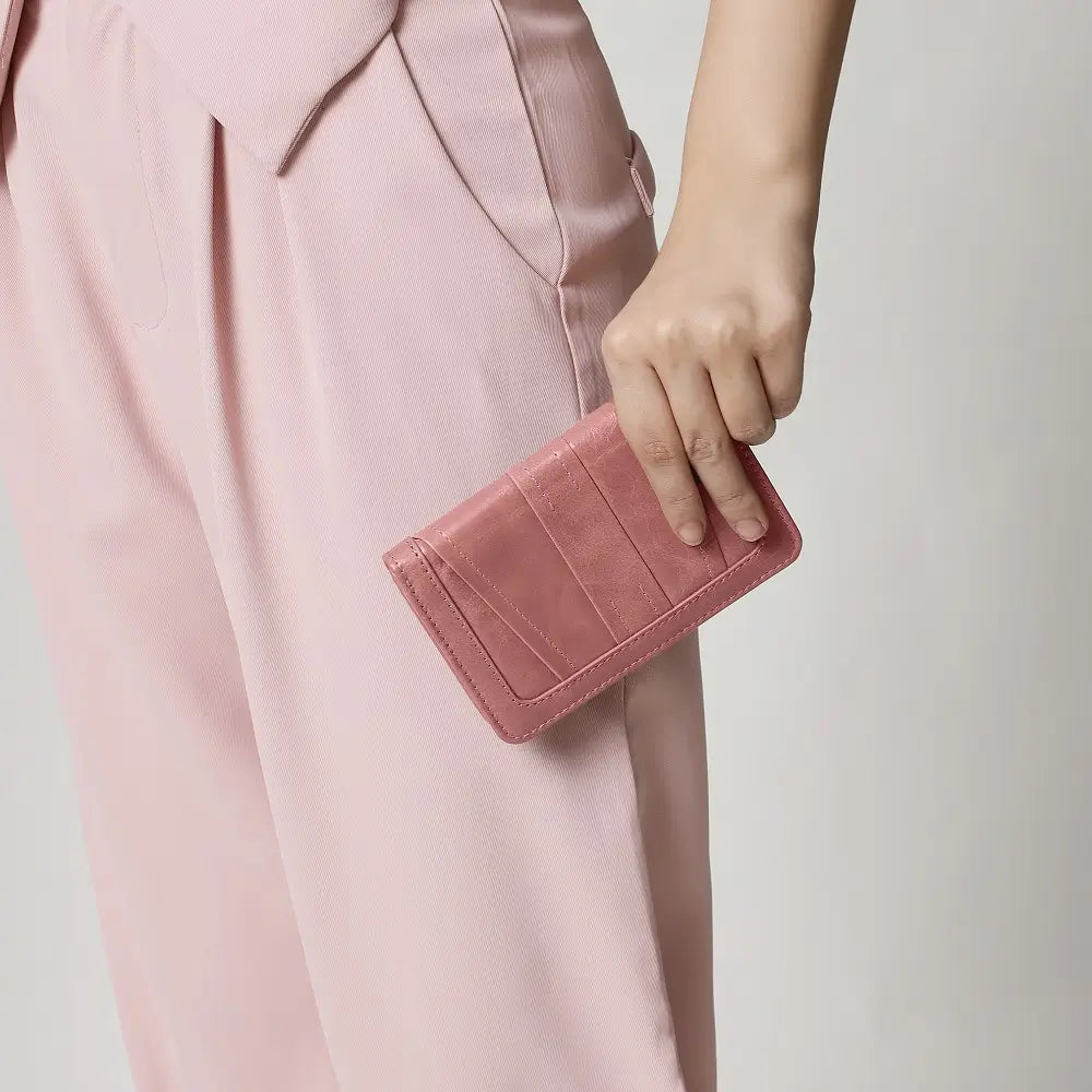 Person holding a brown purse against a plain background