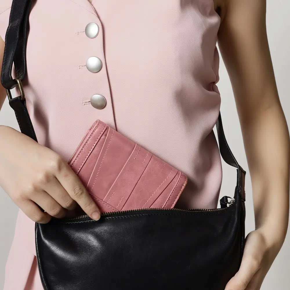 Person holding a brown purse  with a black shoulder bag
