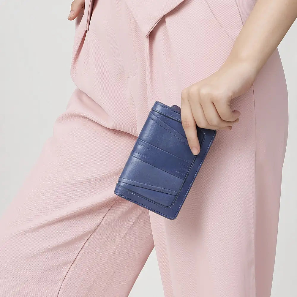 Person holding a Grey Purse with a light pink background