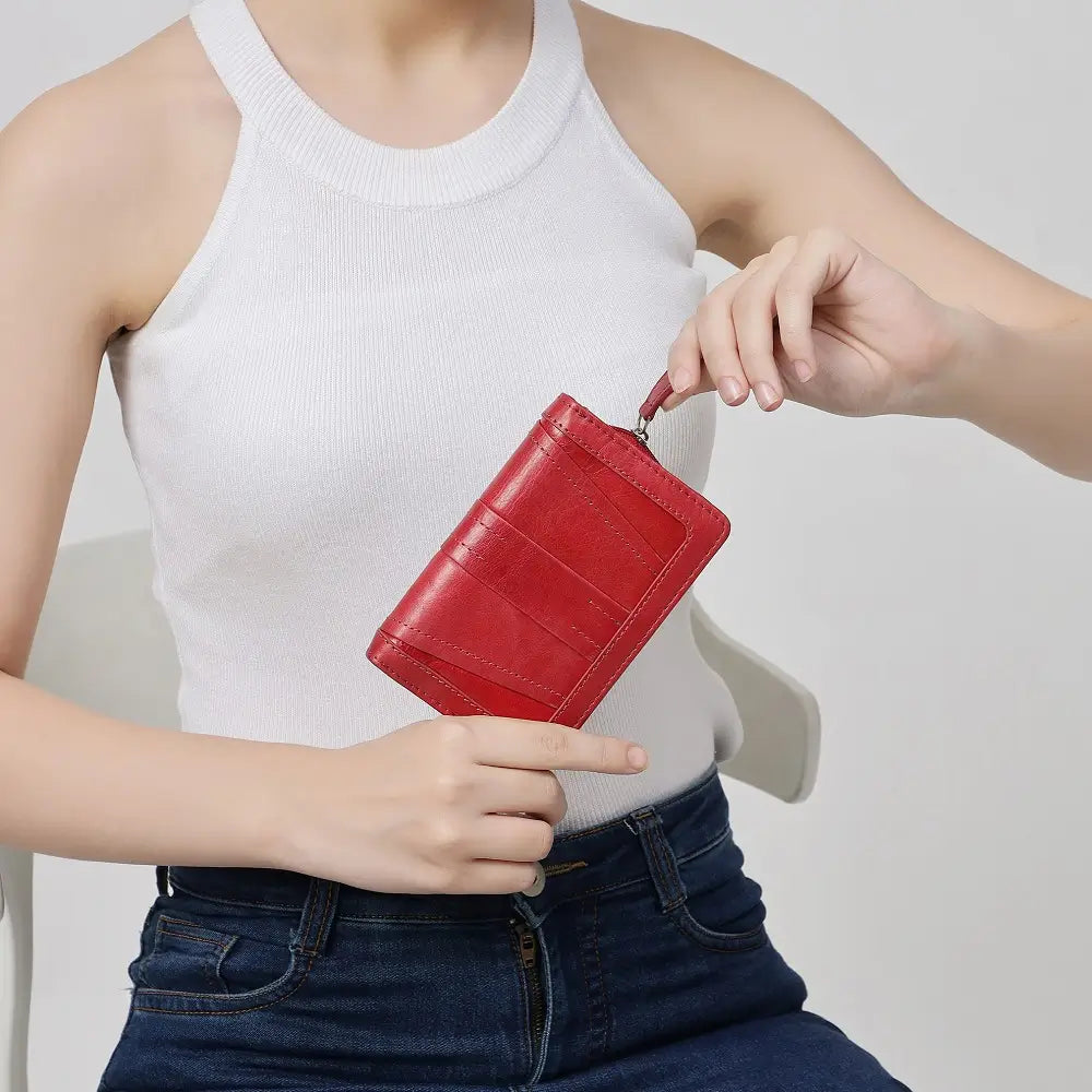 Person holding a red wallet against a plain background