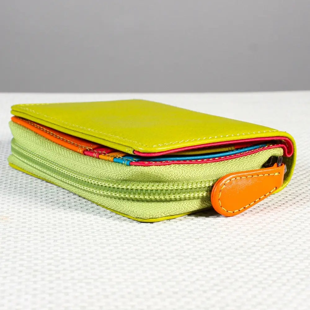 Green zippered pouch with orange zipper pull on a light gray background