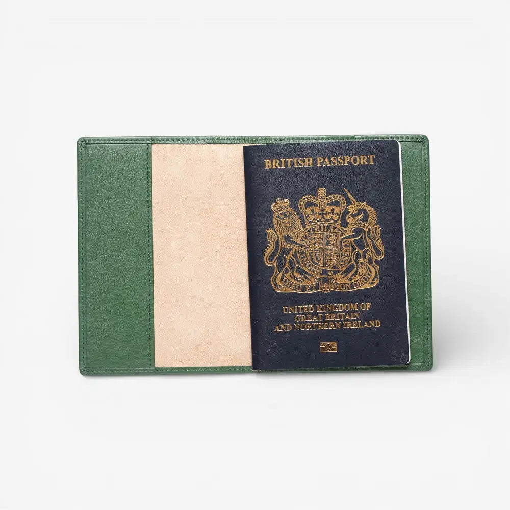 Green passport holder with a British passport inside on a white background