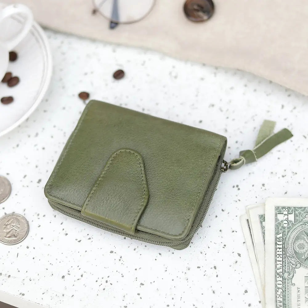 Green wallet on a surface with money and coffee beans