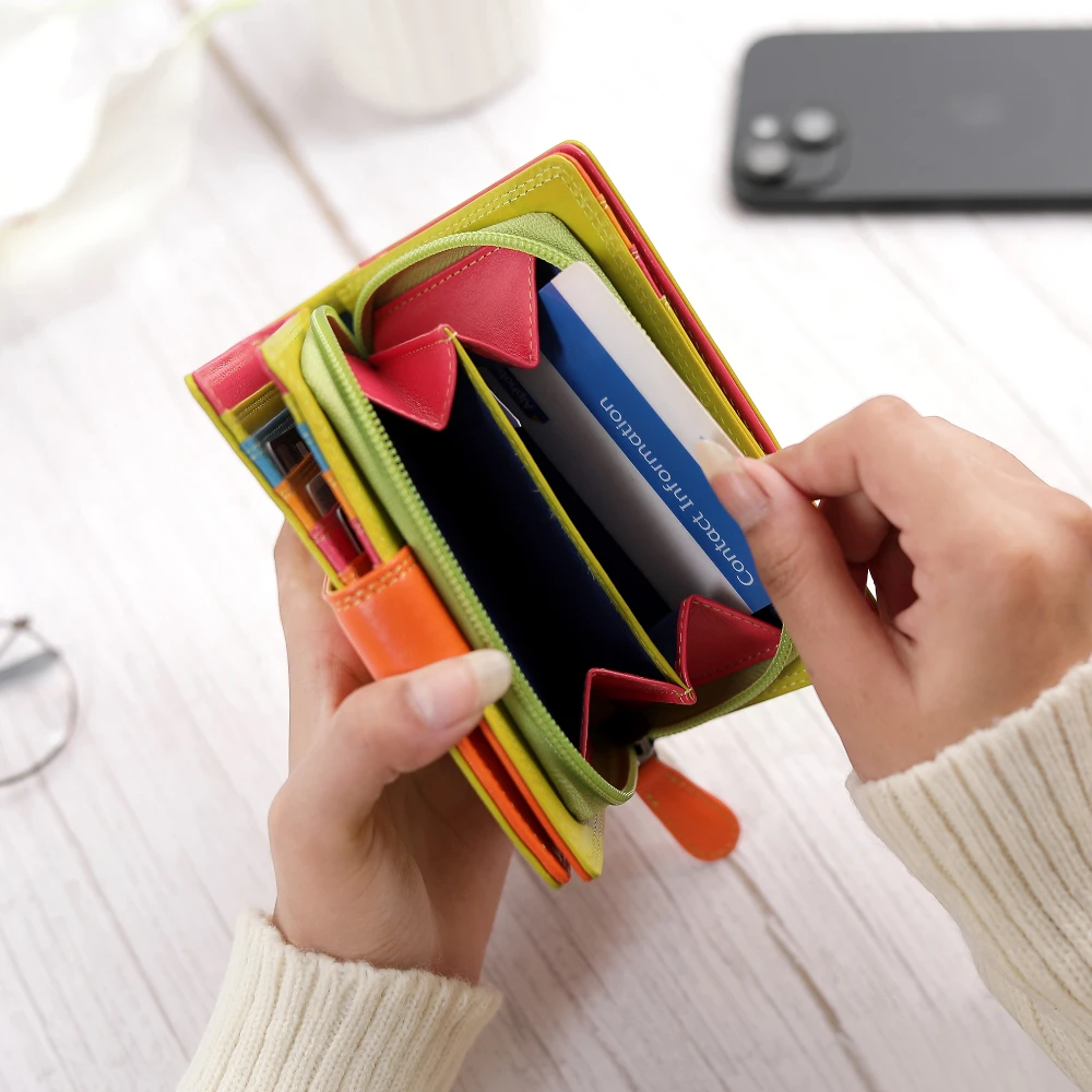 Green wallet with multiple card slots held by a hand on a light background