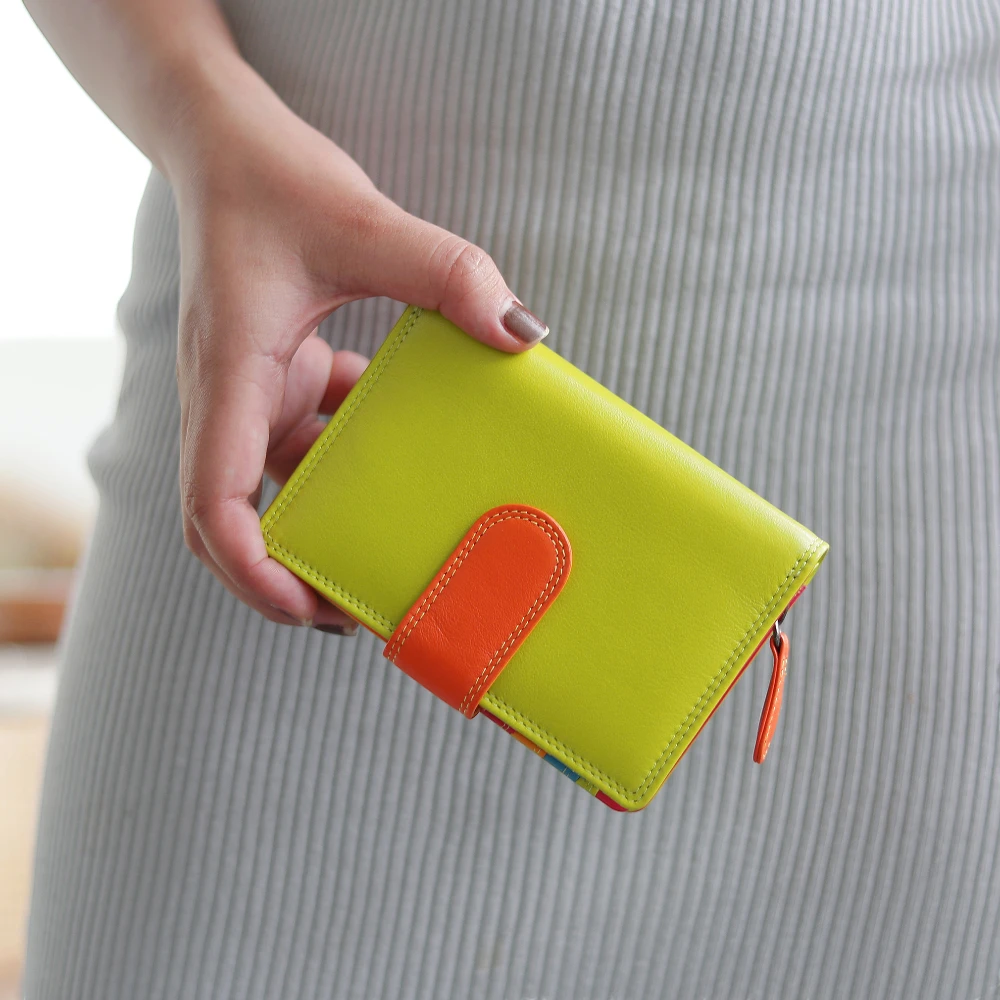 Hand holding a green wallet with an orange accent against a neutral background