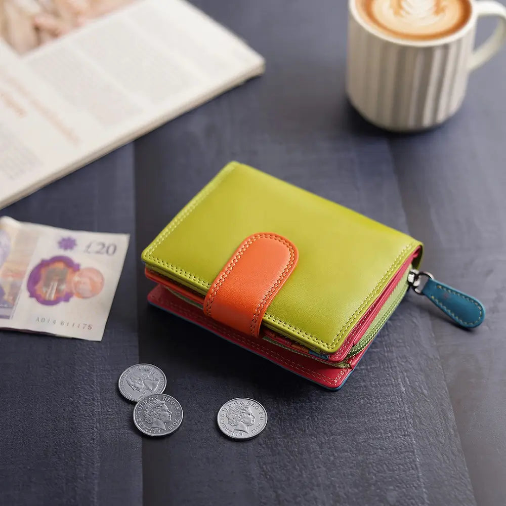 Green wallet with coins and banknotes on a table