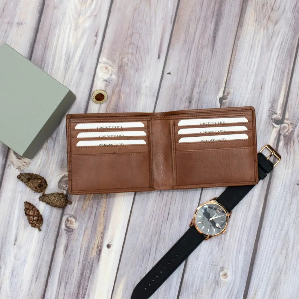 Brown wallet with colorful stripes and black watch on a wooden surface