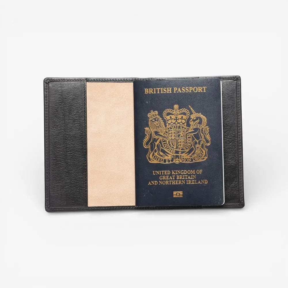 Black passport holder with a British passport inside on a white background