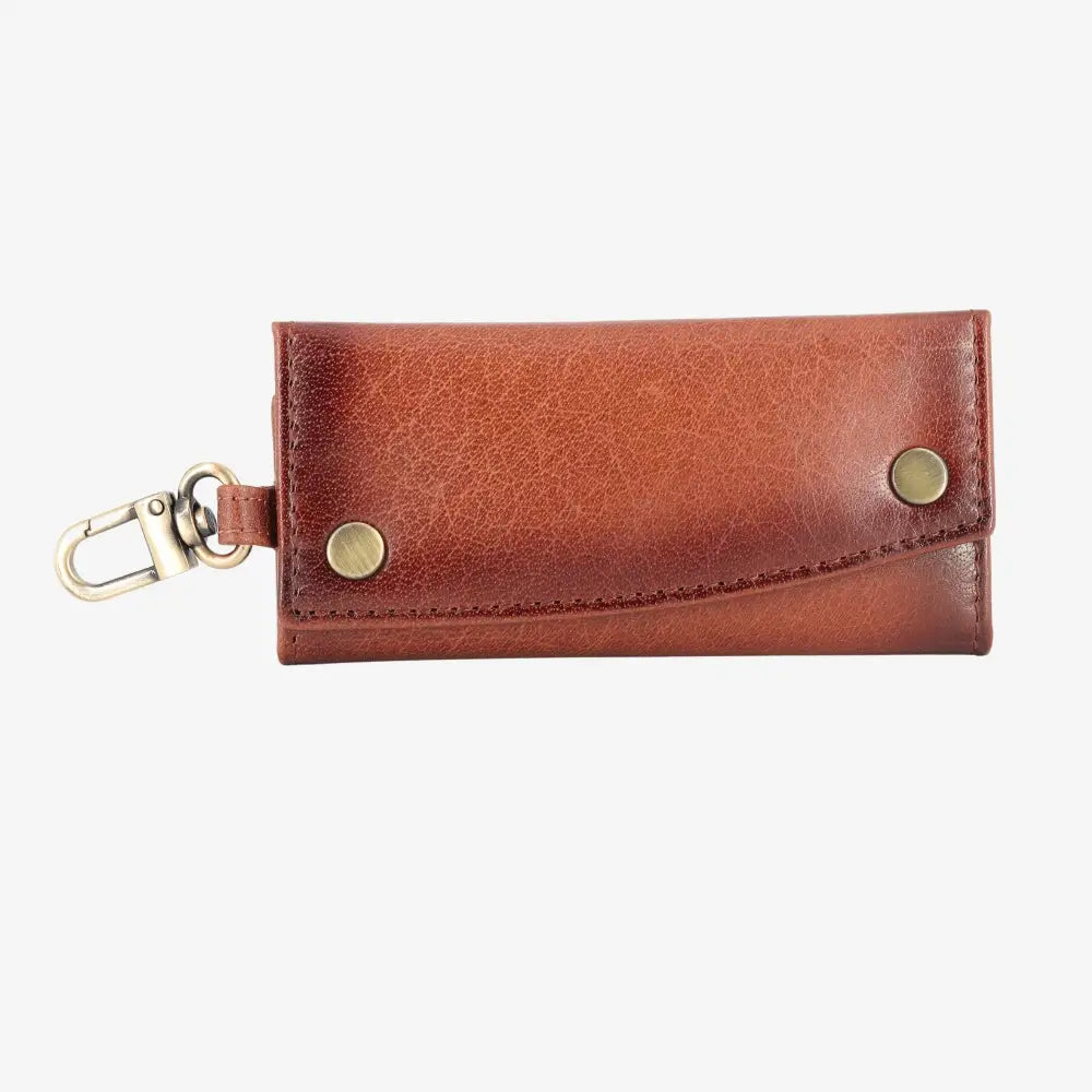 Front view of Brown leather key case with gold accents on a white background