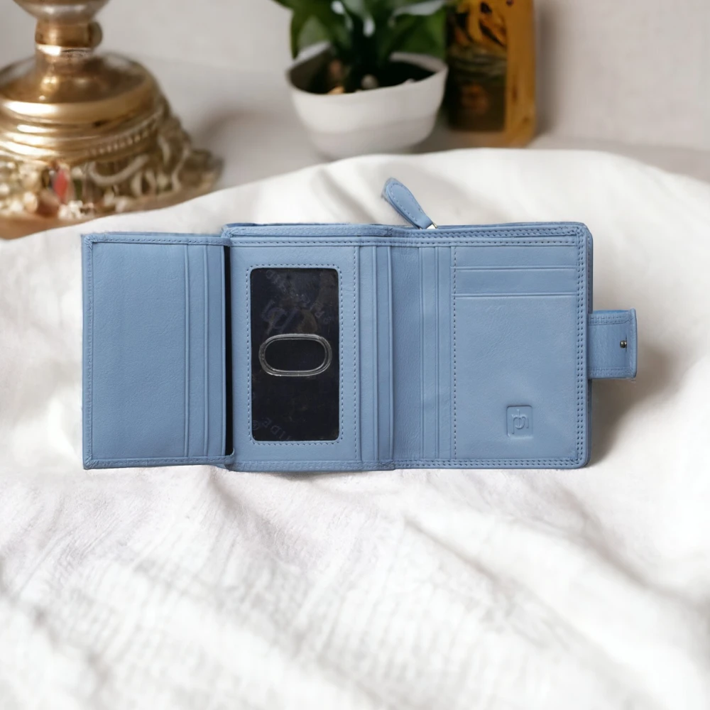 Blue wallet on a white surface with decorative items in the background