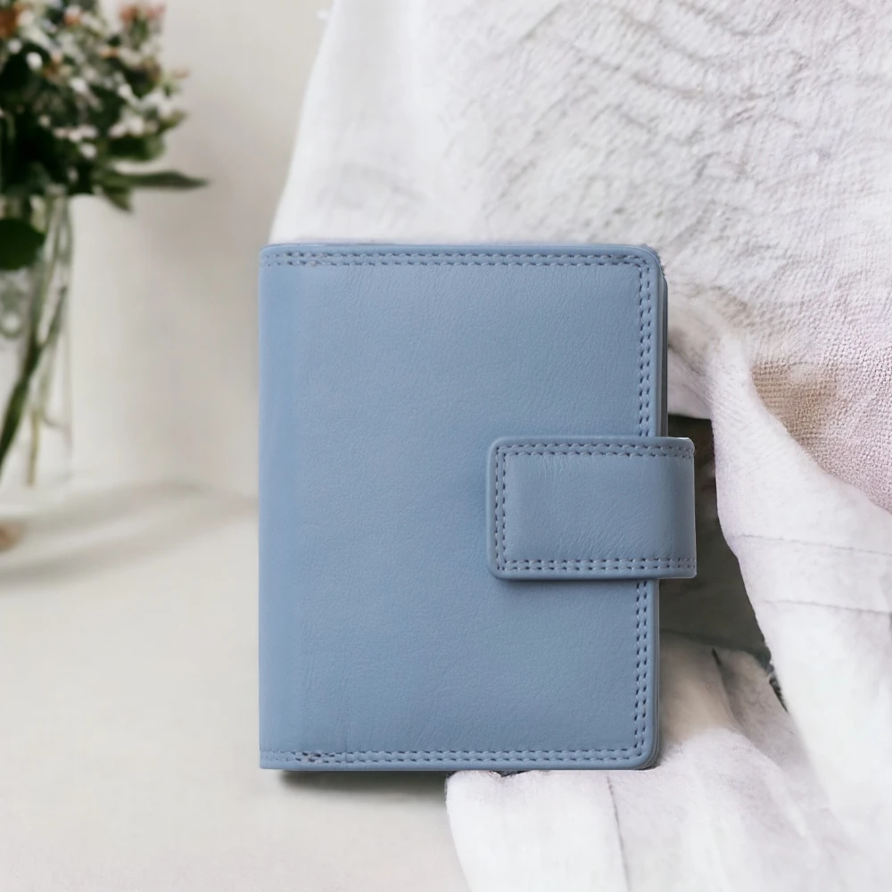 Light blue leather wallet on a white surface with a blurred background