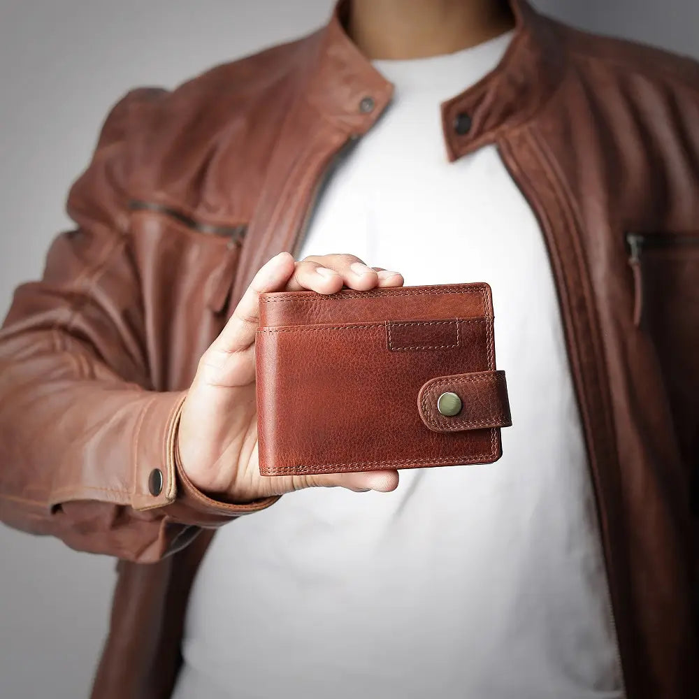 Person holding a brown leather wallet with a blurred background