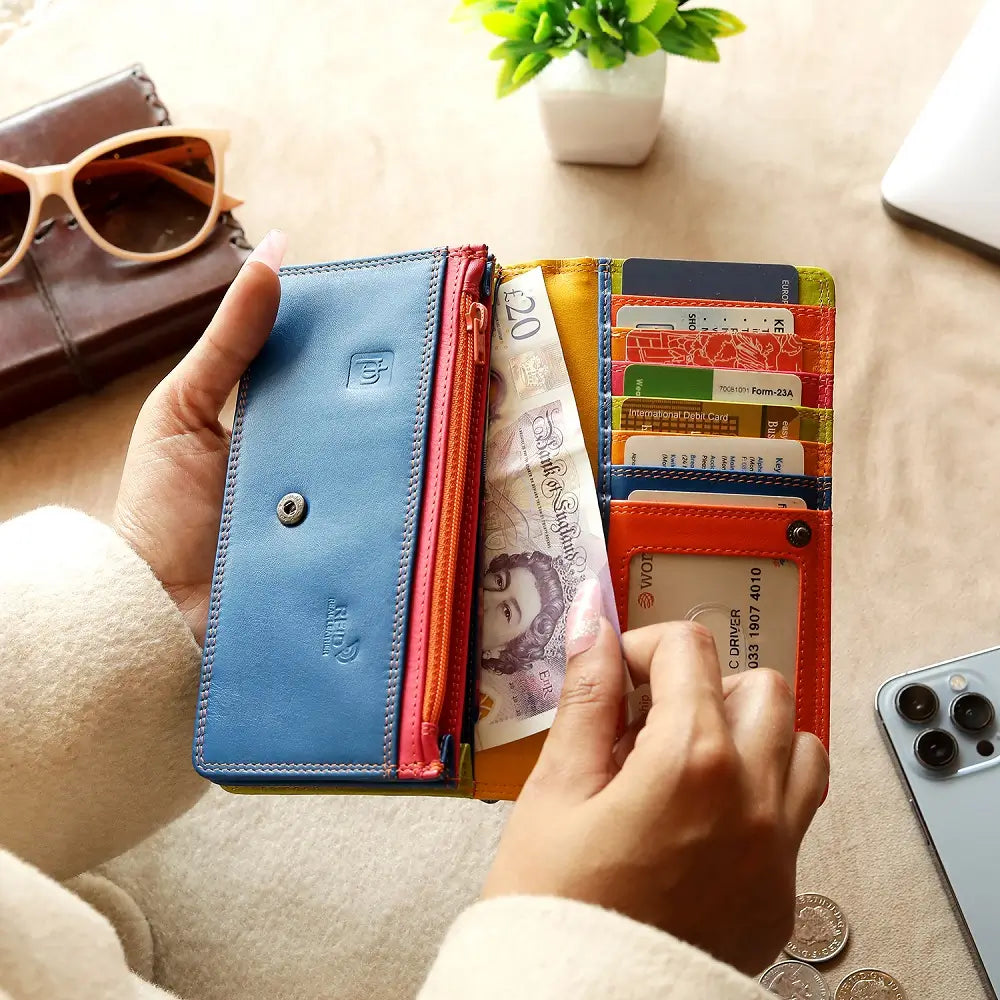 Person holding Orange wallet with blue bottom section on a white background