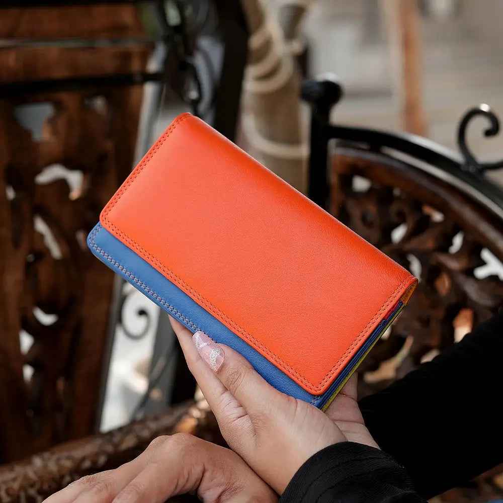 Person holding Orange wallet with blue bottom section on a white background