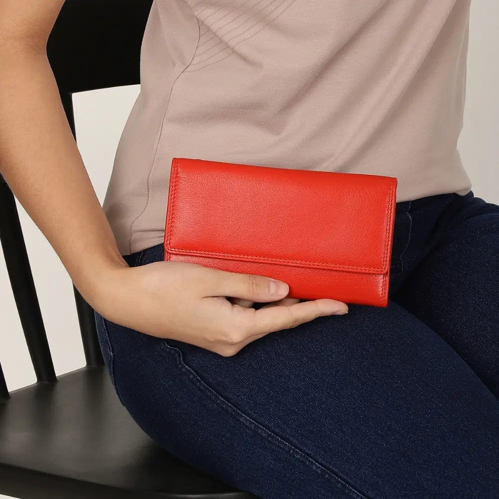 Person holding a Orange wallet with a neutral background
