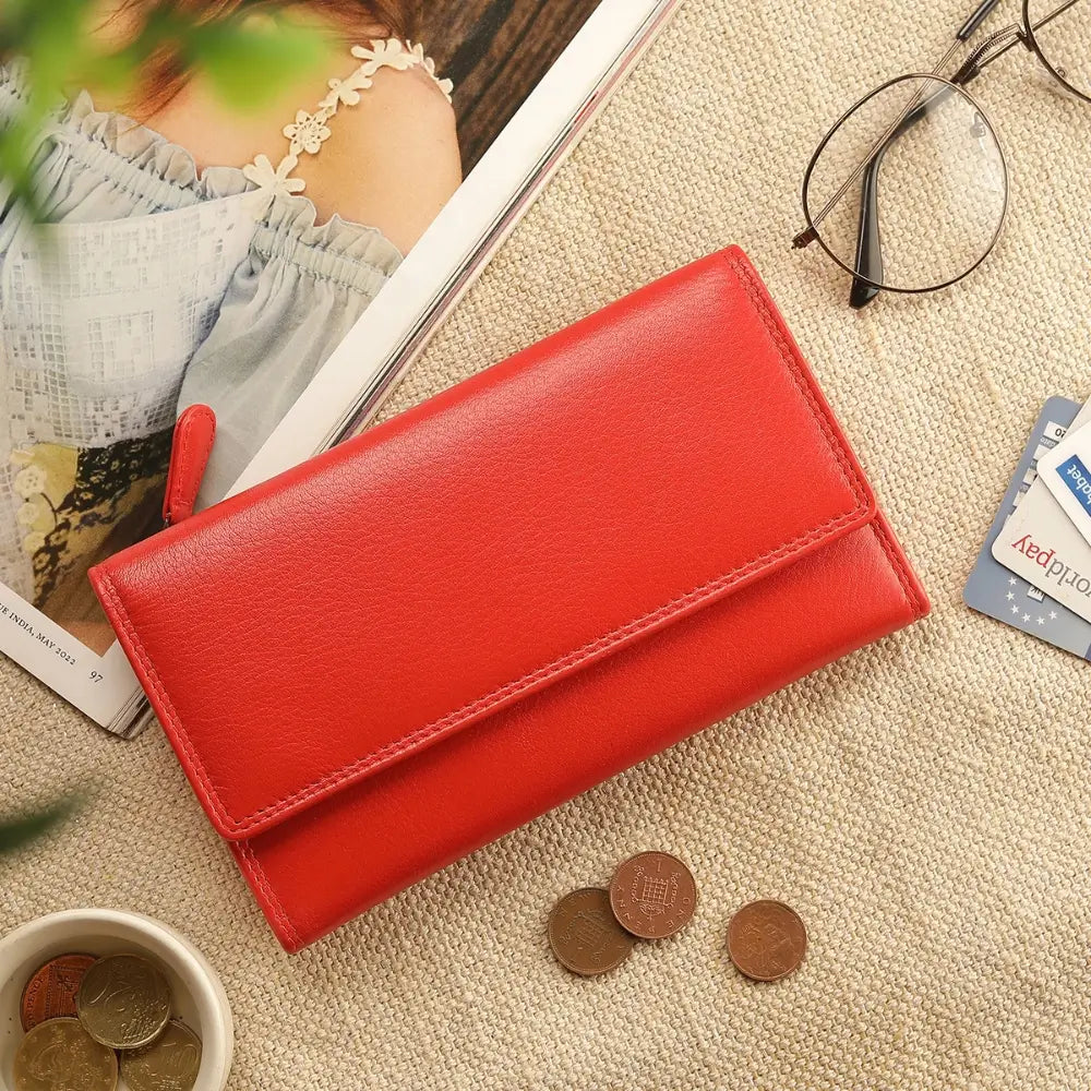 Orange wallet on a textured surface with coins and glasses nearby