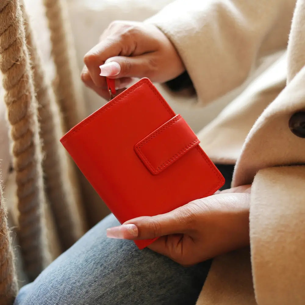 Person holding a orange wallet with a blurred background