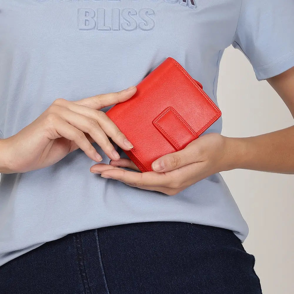 Person holding a orange wallet against a light background