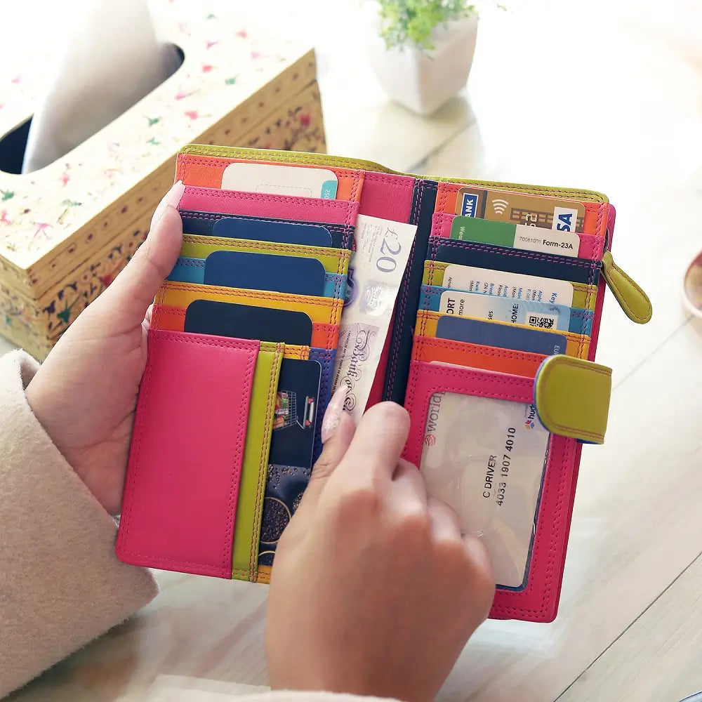 Pink wallet with multiple card slots and a visible passport held by a person.