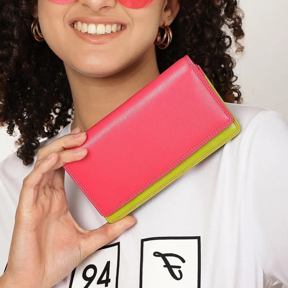 Person holding Pink wallet with green bottom section on a white background